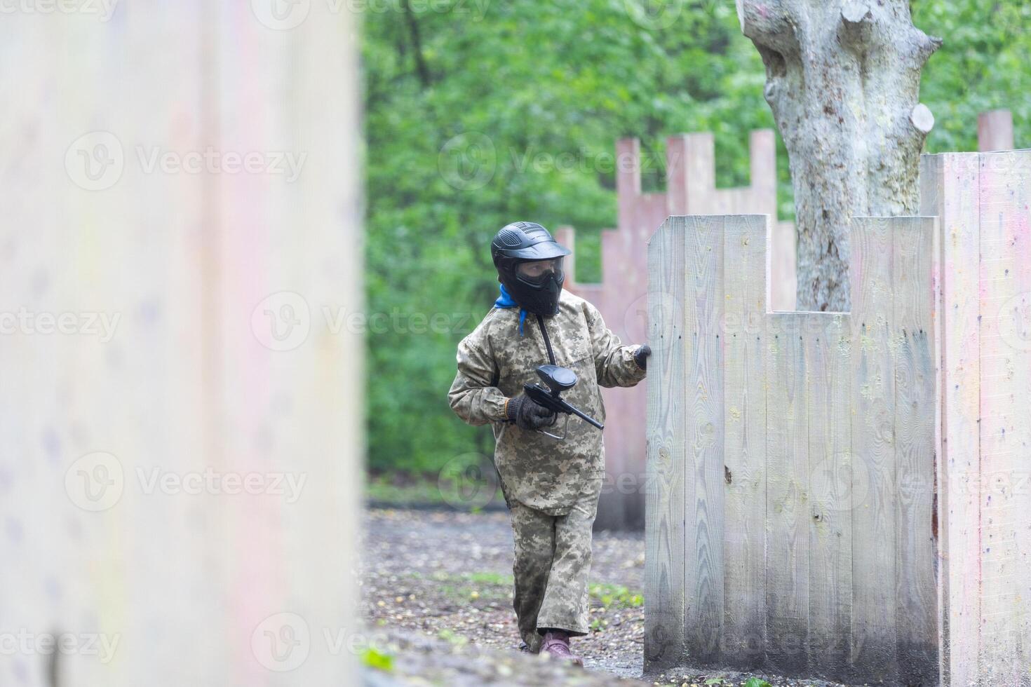 Warriors in camouflage and masks playing paintball photo