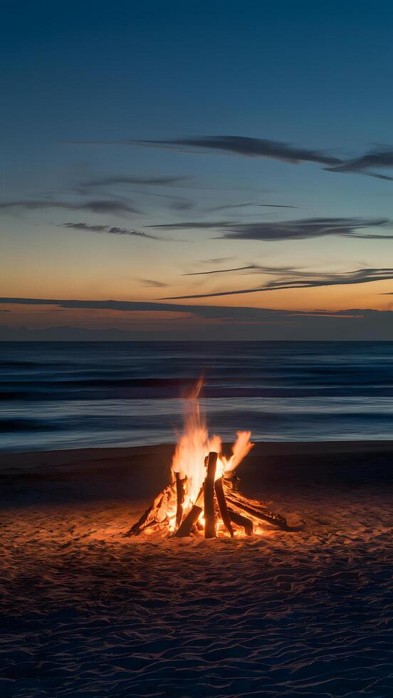 Twilight transforms beach into serene scene with blazing bonfire casting warm light on sand Vertical Mobile Wallpaper photo