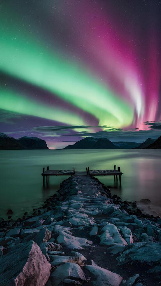 Aurora Borealis lights up the sky with green and pink hues over water Vertical Mobile Wallpaper photo