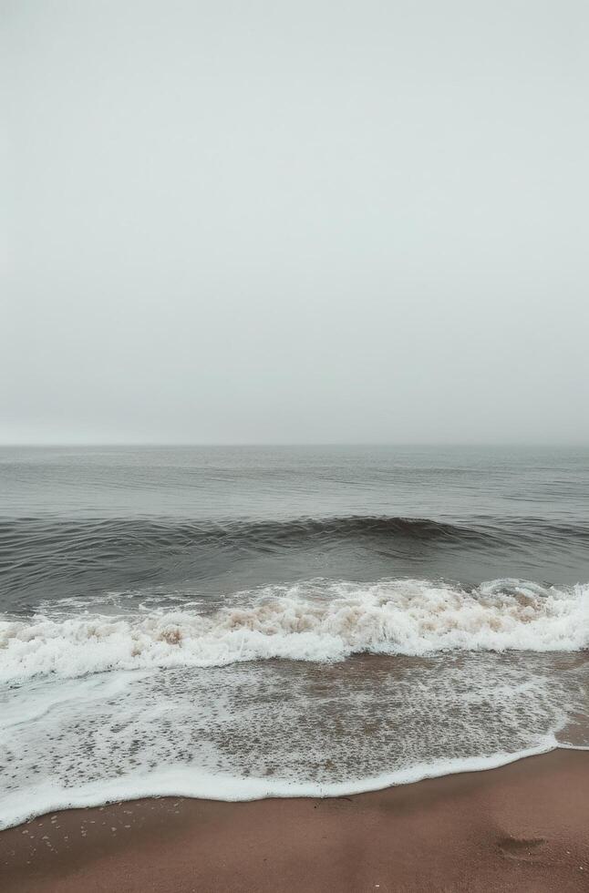 Grey Skies and Foamy Waves on a Sandy Beach photo