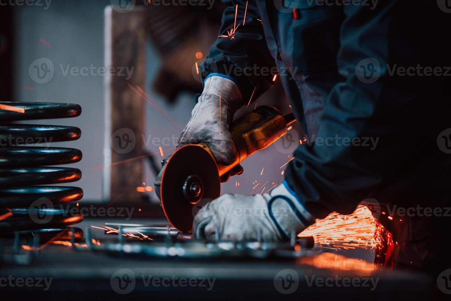 Locksmith in special clothes and goggles works in production. Metal processing with angle grinder. Sparks in metalworking. photo