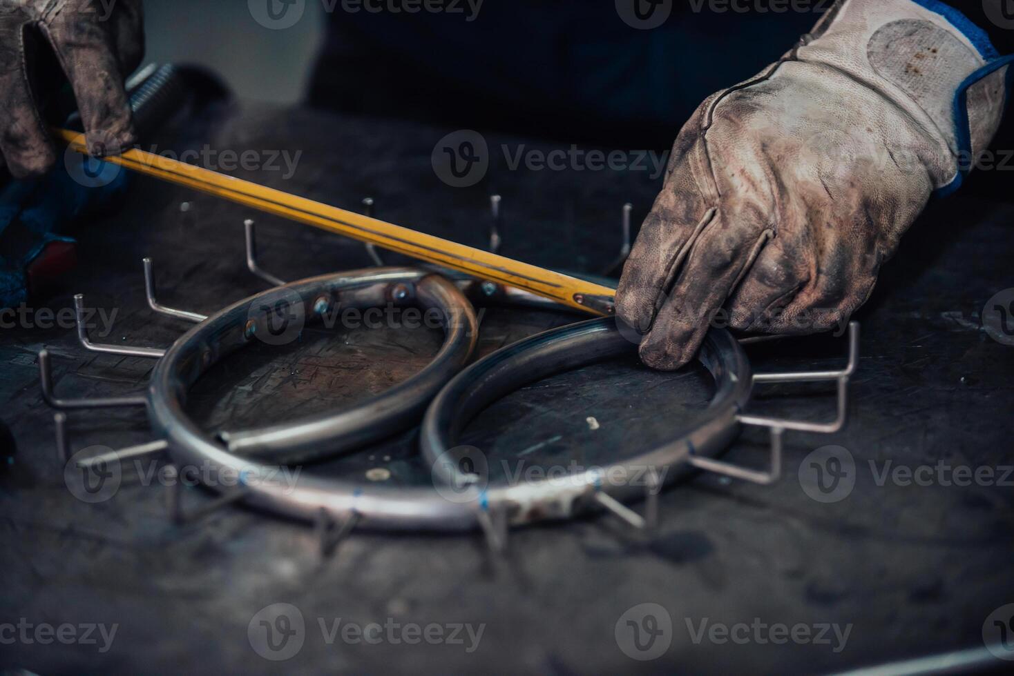 The locksmith measures the pieces of steel and preparing them for welding photo