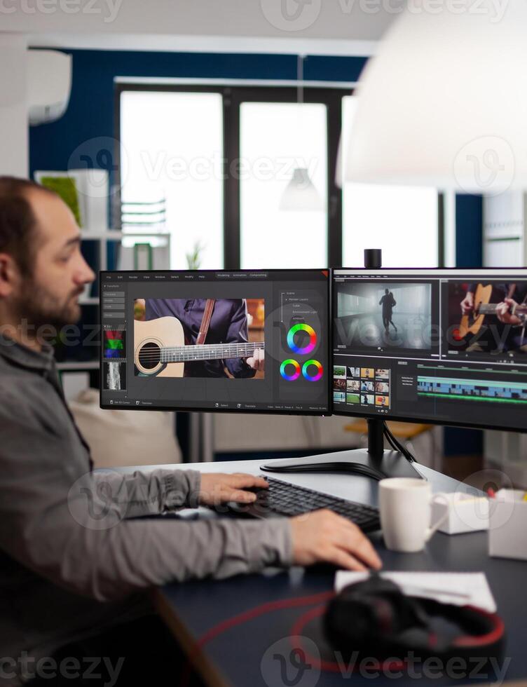Manager production editing project working in start up creative agency office at pc with two monitors. Man processing film montage in digital multimedia company using post production software photo