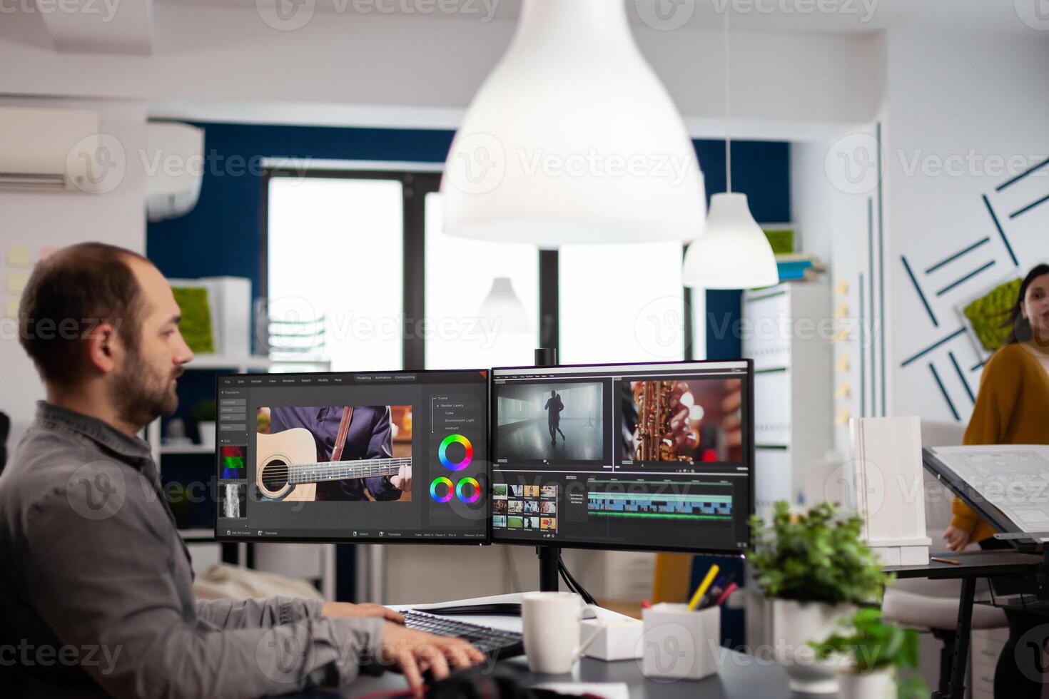 Videographer editing, cuting footage and sound on computer with dual monitors setup working in creative agency office. editor man processing film montage in digital multimedia star up company. photo