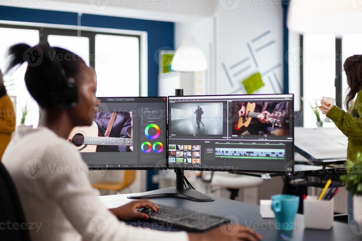 African editor working with footage and sound, editing new project cutting film montage sitting in modern agency office. Woman using computer processing movie in post production software photo