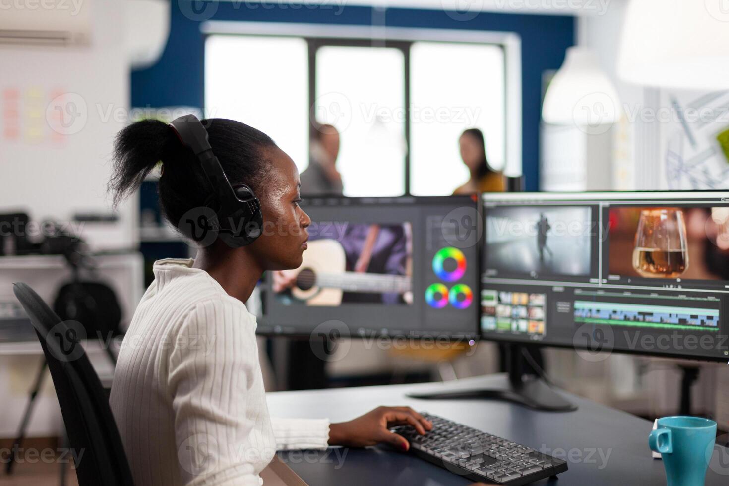 Black woman editor developing new project film montage sitting in modern creative agency office. Content creator in digital multimedia company processing movie with post production software photo