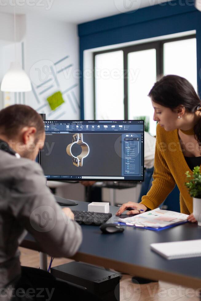 Coworkers engineer architects working on modern cad program developing construction metalic components. Industrial designer studying prototype idea on pc showing digital software with gears photo