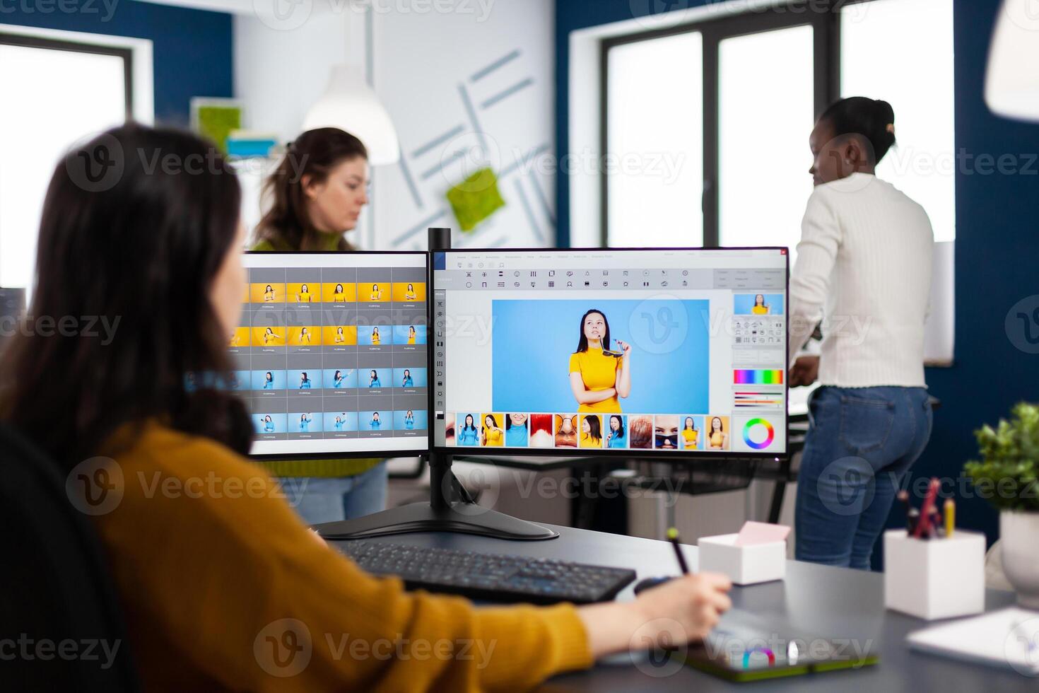 Photo graphic editor retouching photos of client in professional app with stylus pen working in start up creative studio. Photographer using computer editing digital assets in post production software