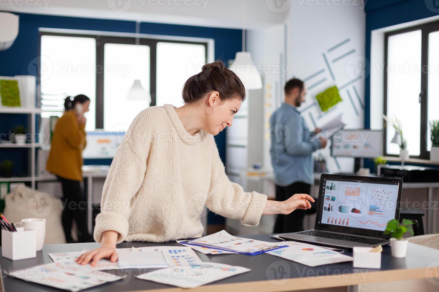 Business analyst working on new financial strategy looking at laptop display. Executive entrepreneur, manager leader standing working on projects with diverse colleagues. Successful corporate professional entrepreneur online internet statistics photo