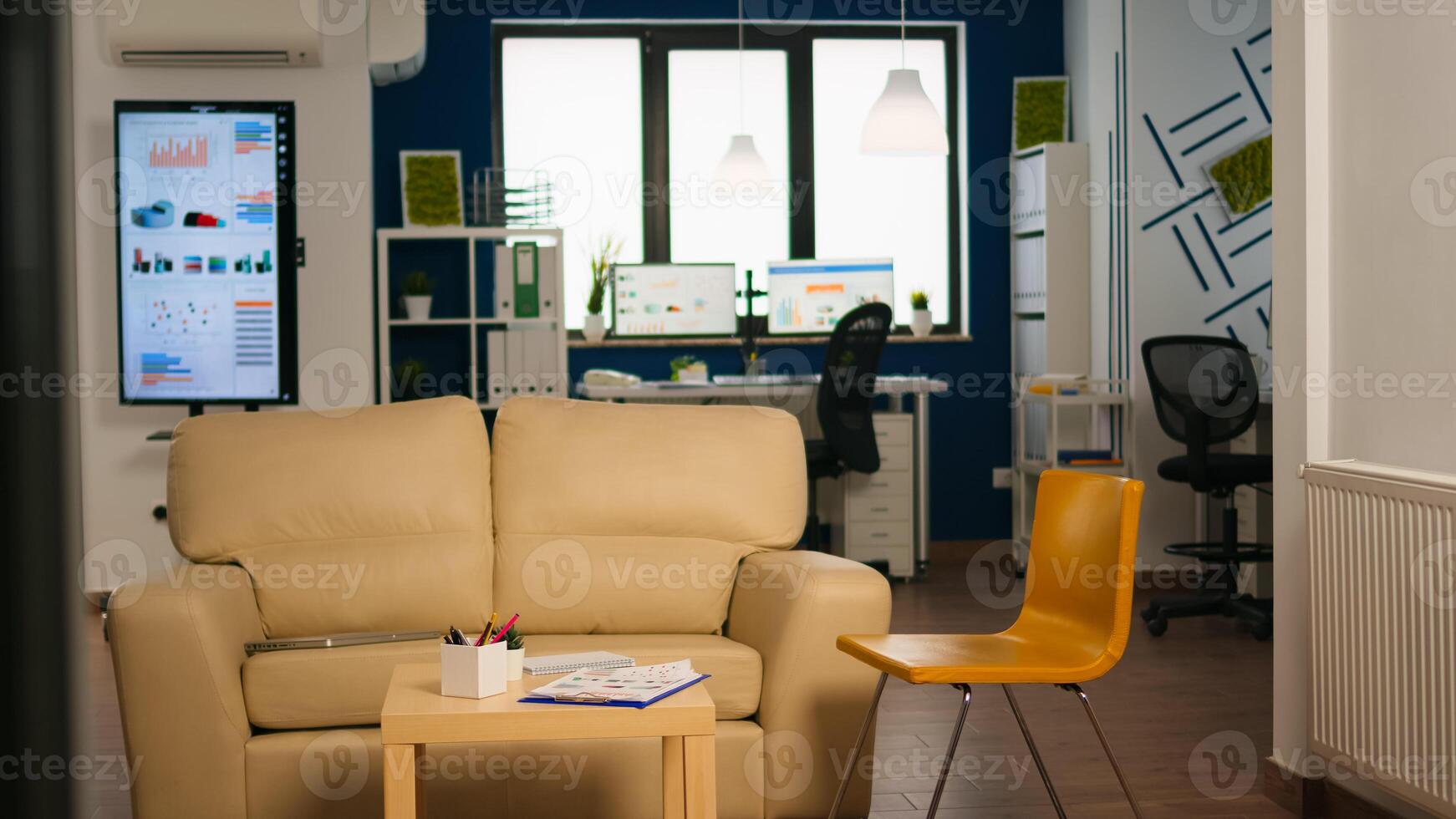 Interior of modern open plan office with no people, stylish room interior with table couch and chairs. Rest area in business center with small sofa, shot of empty room with modern furniture. photo