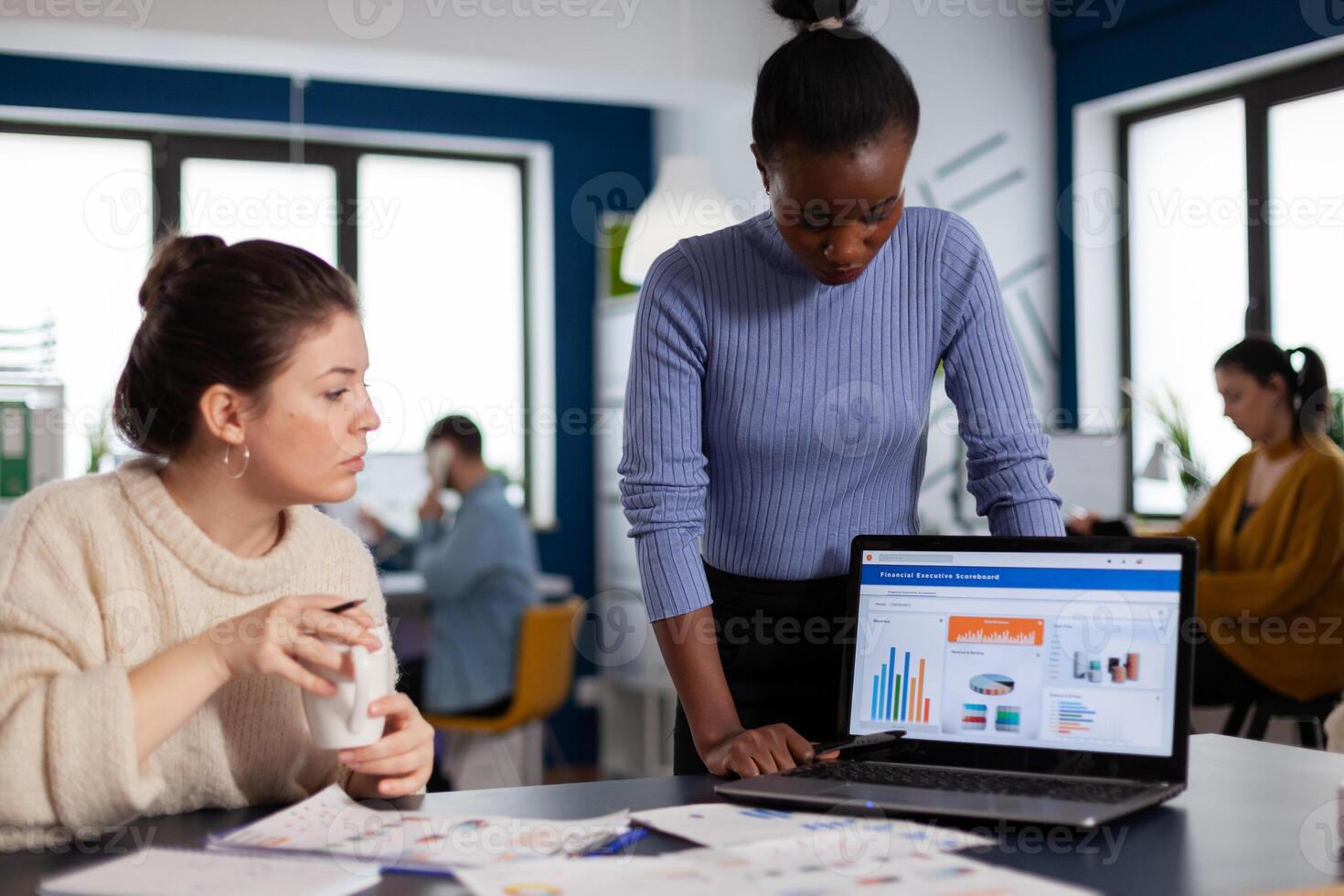 Diverse team of financial company working together on corporate charts and statistics. Multiethnic employees gathered in co-working space of startup new business. photo