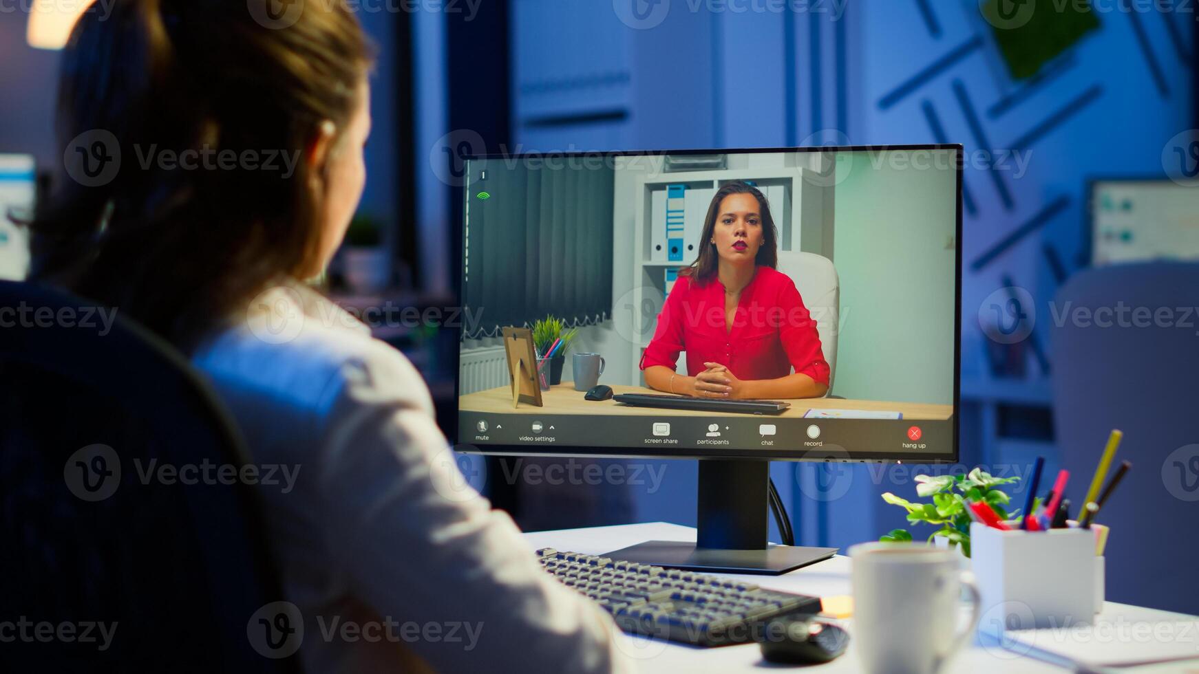 Manager woman talking with coworker during conference at midnight from business office planning financial strategy. Lady using modern technology network wireless discussing at virtual meeting photo