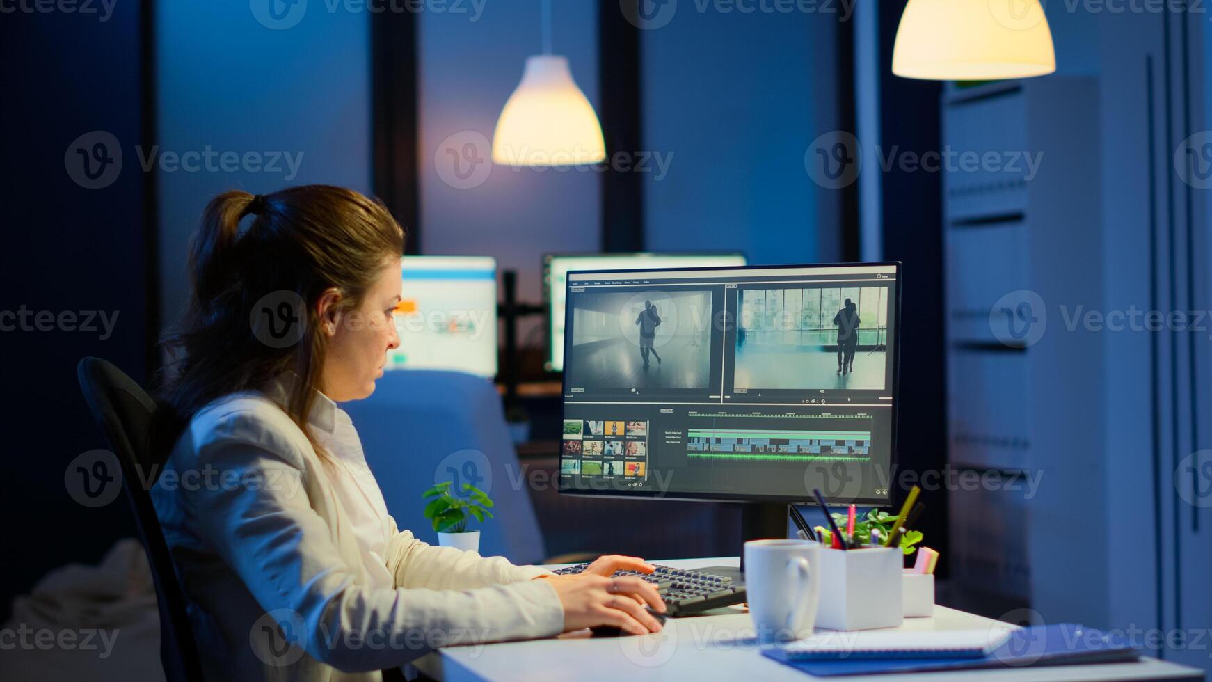 Videographer working at computer from business office, editing and audio footage at night. Content creator using professional device modern technology network wireless processing film montage. photo