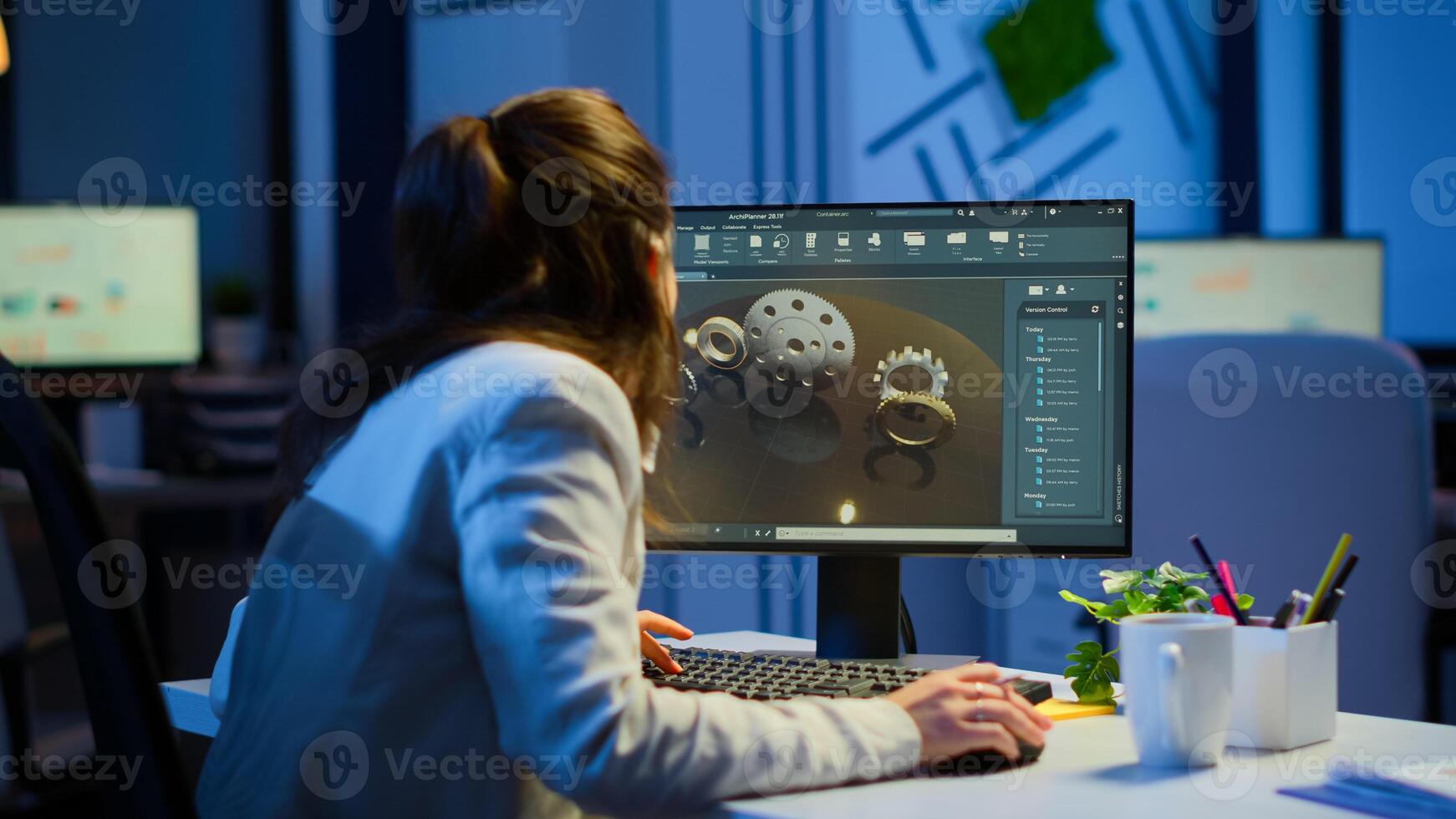 Woman architect working in modern cad program overtime sitting at desk in start-up business office. Industrial employee studying prototype idea on computer showing cad software on device display photo