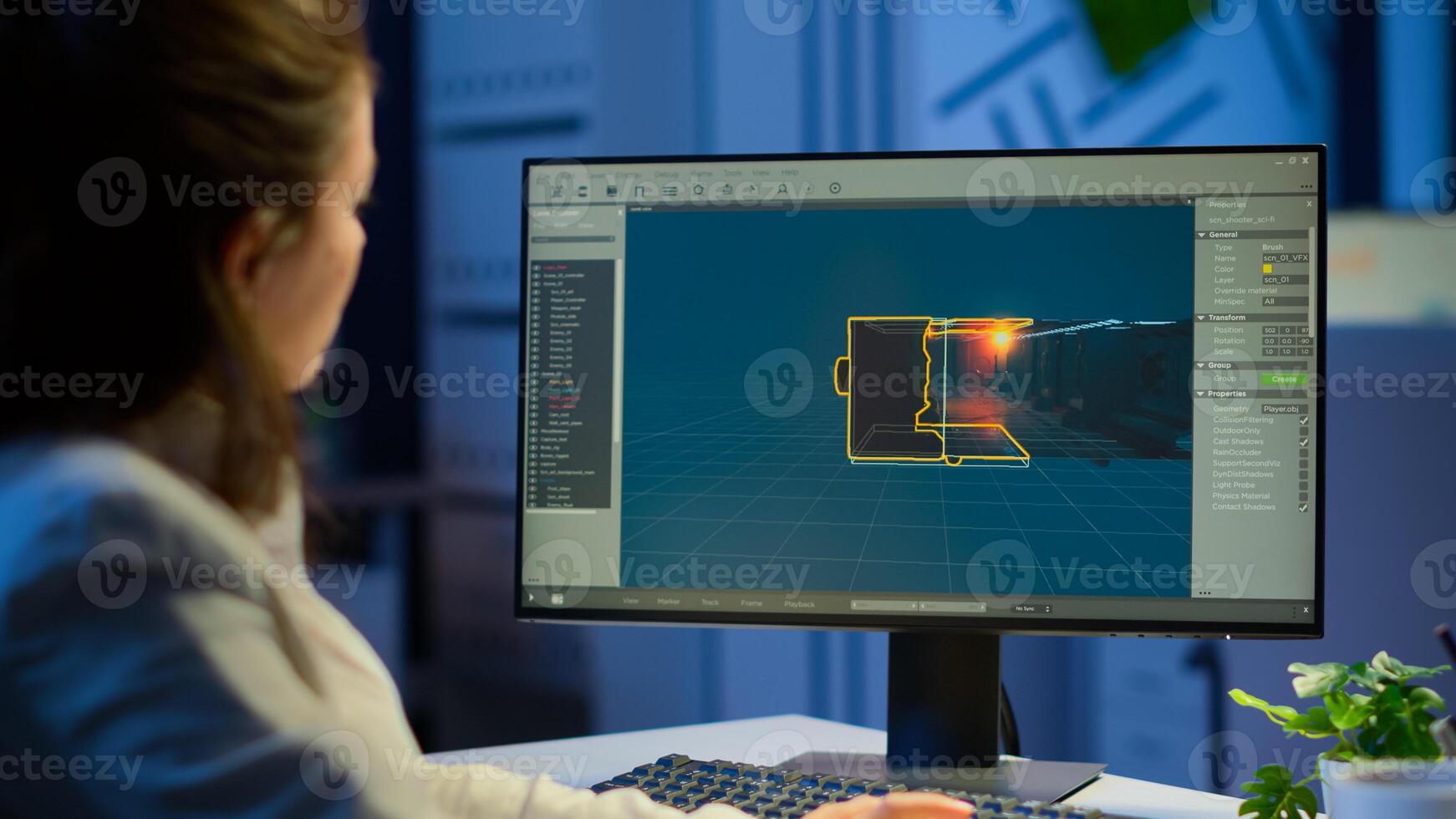 Young woman game designer looking at computer screen working at project studio office late at night. Tired worker developing new online games on pc with modern technology photo