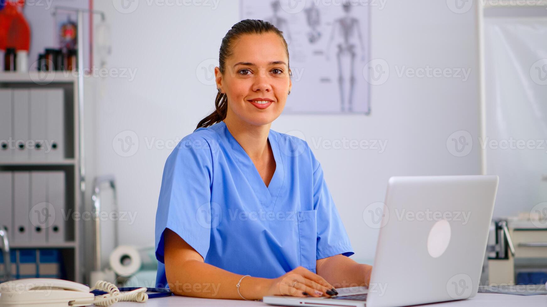 Portrait of professional medical nurse in blue practitioner uniform smiling at camera. Hospital healthcare worker, medicine clinical assistant health consultant therapist, telemedicine and healthcare support photo