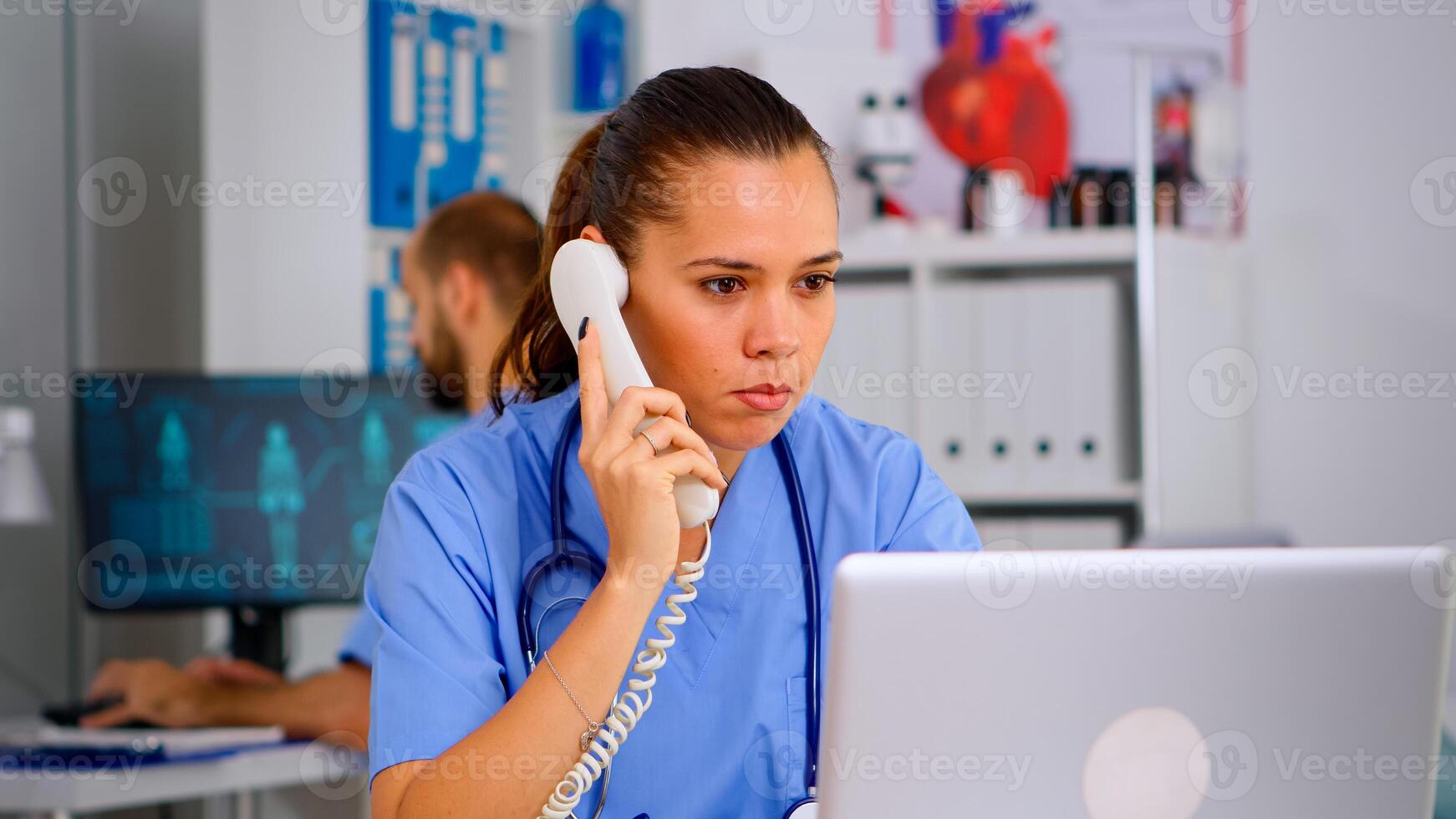 Medical practitioner answering phone calls and scheduling appointments in hospital. Healthcare physician in medicine uniform, receptionist doctor assistant helping with telehealth communication photo