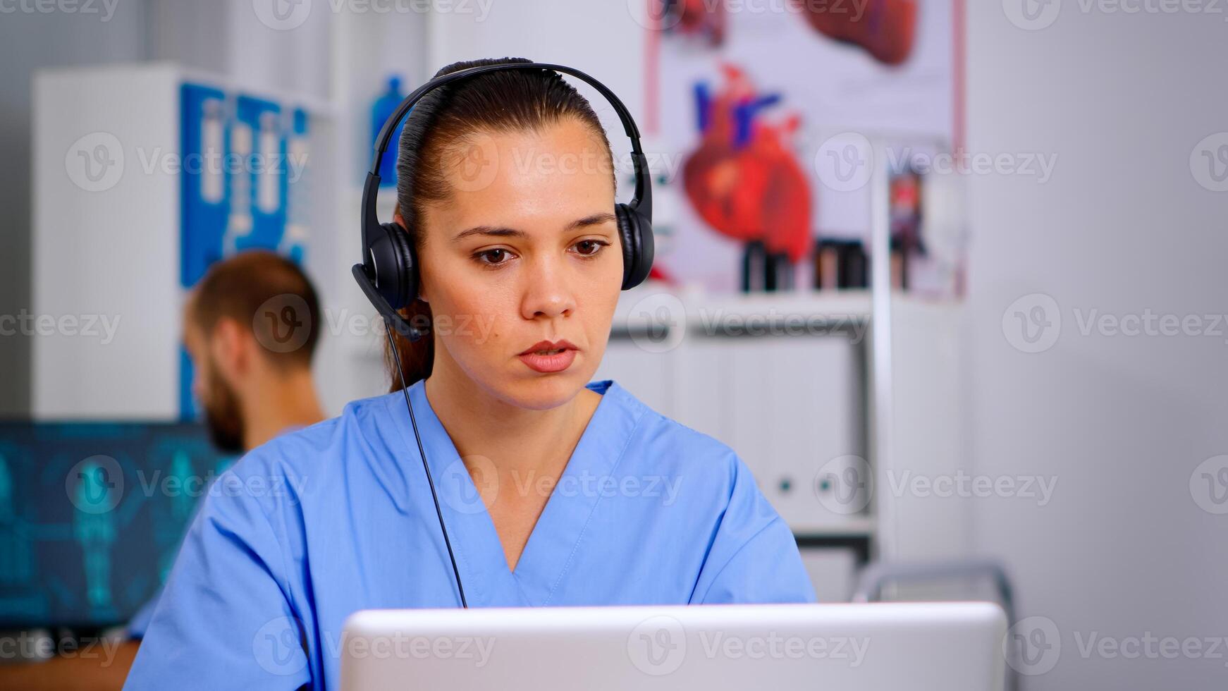 Doctor assistant using headphones in hospital answering to patients calls for appointments and consultations. Healthcare physician in medicine uniform, doctor nurse helping with telehealth communication photo