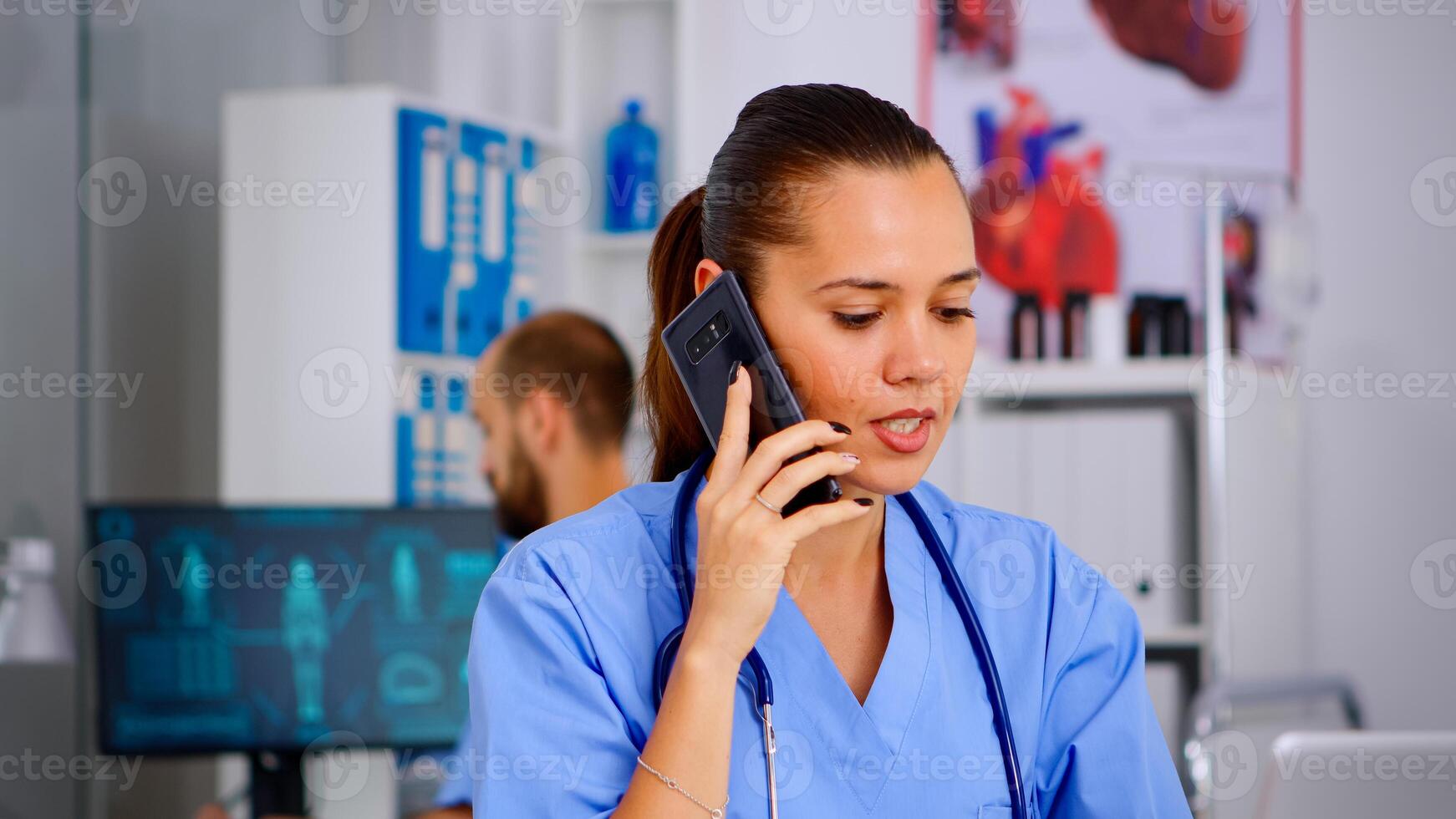 Medical assistant talking at smartphone with doctor asking for advice, typing on laptop, making appointments Healthcare physician in medicine uniform, nurse helping with telehealth communication photo