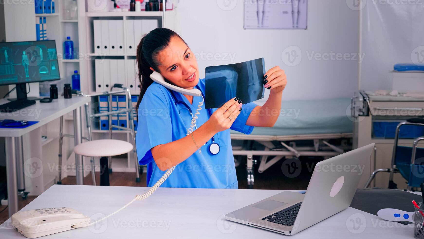 Physician nurse speaking at phone with patient analysing radiographics discussing the diagnosis, making appointment. Therapist, doctor assistant helping with telehealth communication, consultation photo
