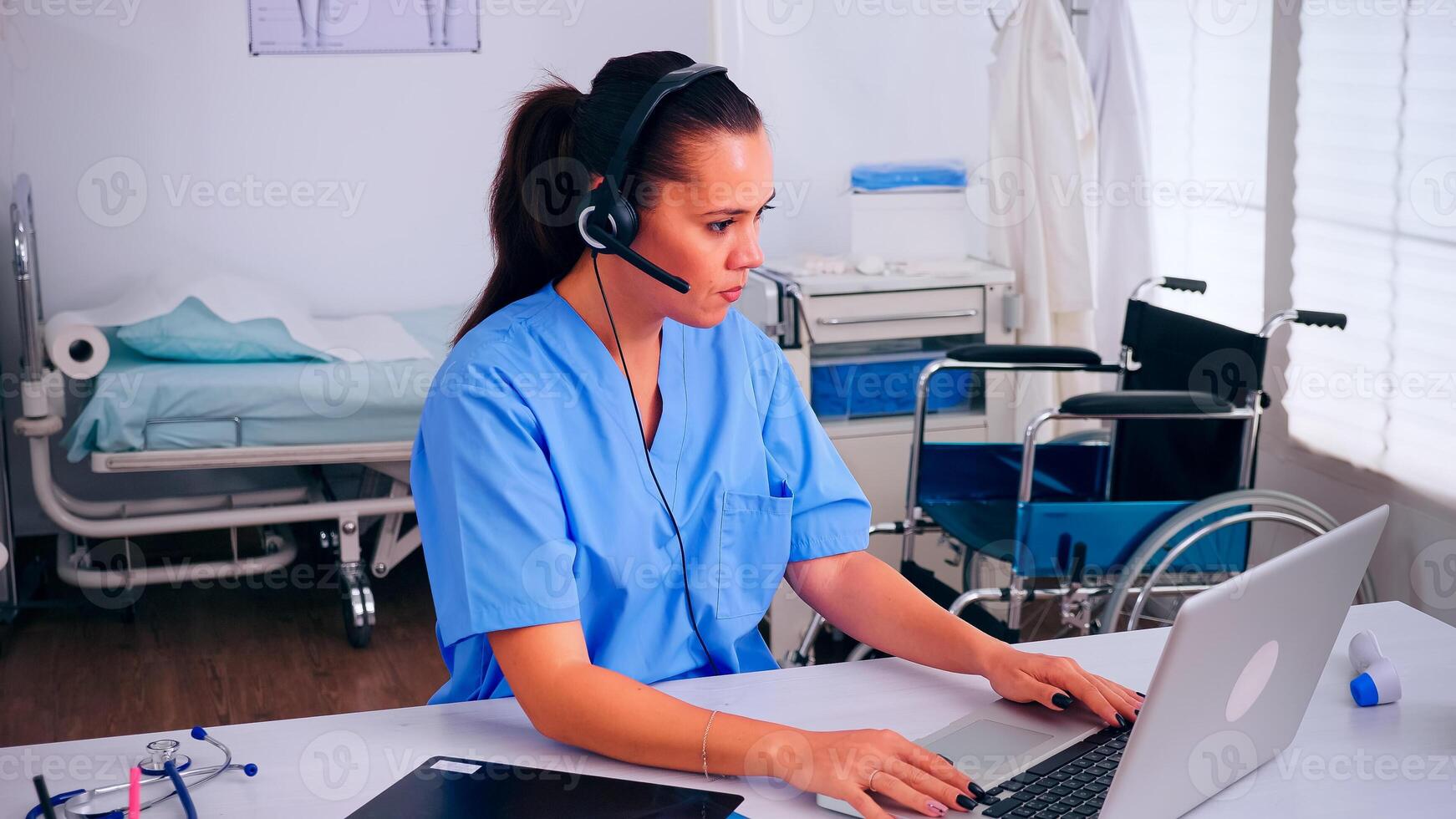 Receptionist, operator speaking online with patients using headphone helping people with health problems sitting in hospital workplace. Healthcare physician, assistant during telehealth communication photo