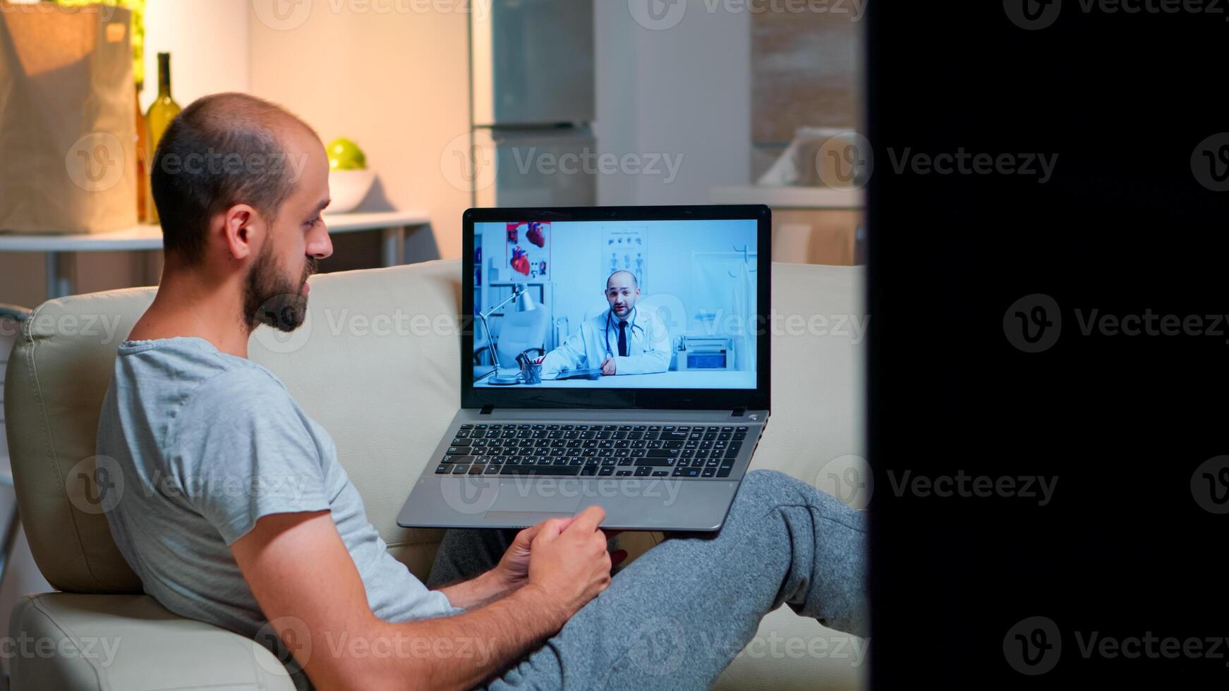 Sick man having online telemedicine consultation during covid-19. Caucasian male sitting in front of laptop disscusing with medical physician about illness symptoms working on healthcare treatment photo