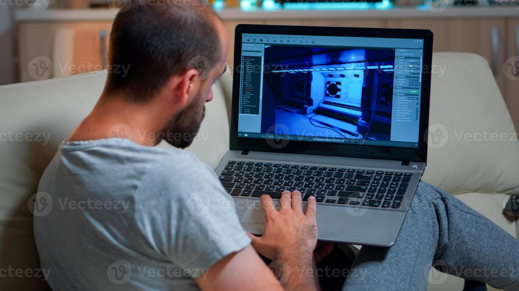 Caucasian game developer working on gameplay and game level late at night from the confort of his home. Professional creative man in the evening developing startup technology photo