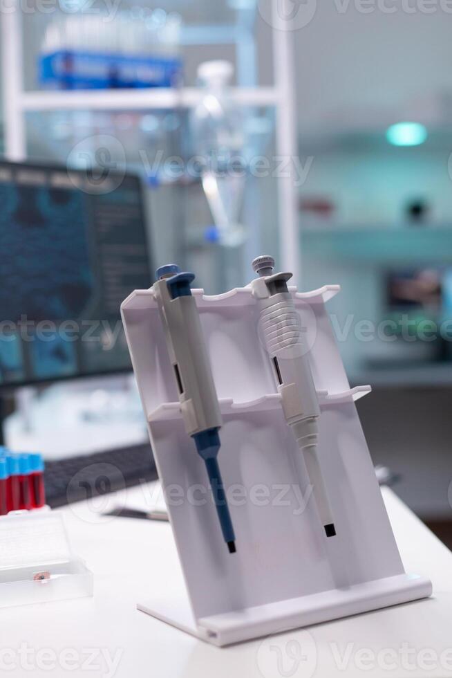 Medical micropipette standing on table ready for microbiology scientific test experiment in biology science hospital laboratory. Clinical biological instrument. Healthcare investigation photo
