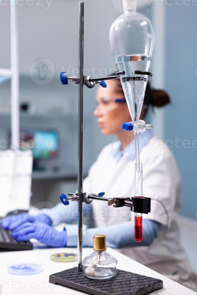 Specialist pharmacist woman typing bacteriology infection test results on computer analyzing pharmaceutical medical expertise in hospital laboratory, Biologist doctor working at medicine experiment photo