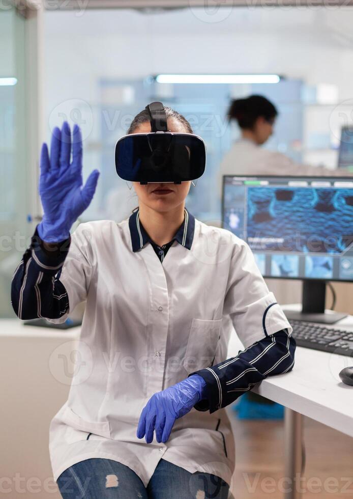 Laboratory doctor experiencing virtual reality using vr goggles in medical research lab. Team of researchers working with equipment device, future, medicine, healthcare, professional, vision, simulator. photo
