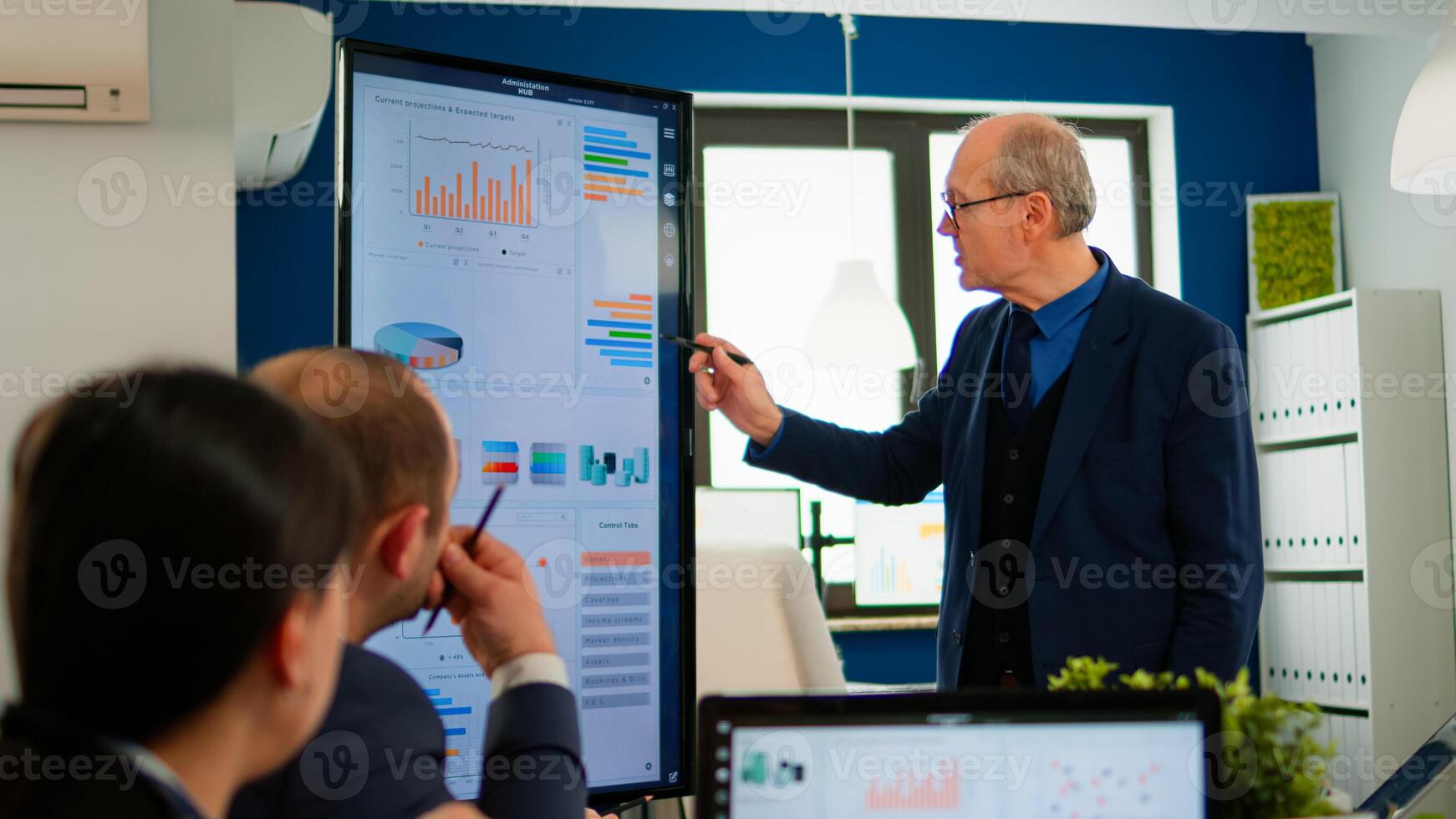 Experienced project leader analysing financial presentation during business conference in brainstorming room using digital devices. Multiethnical team working in professional startup company during meeting photo