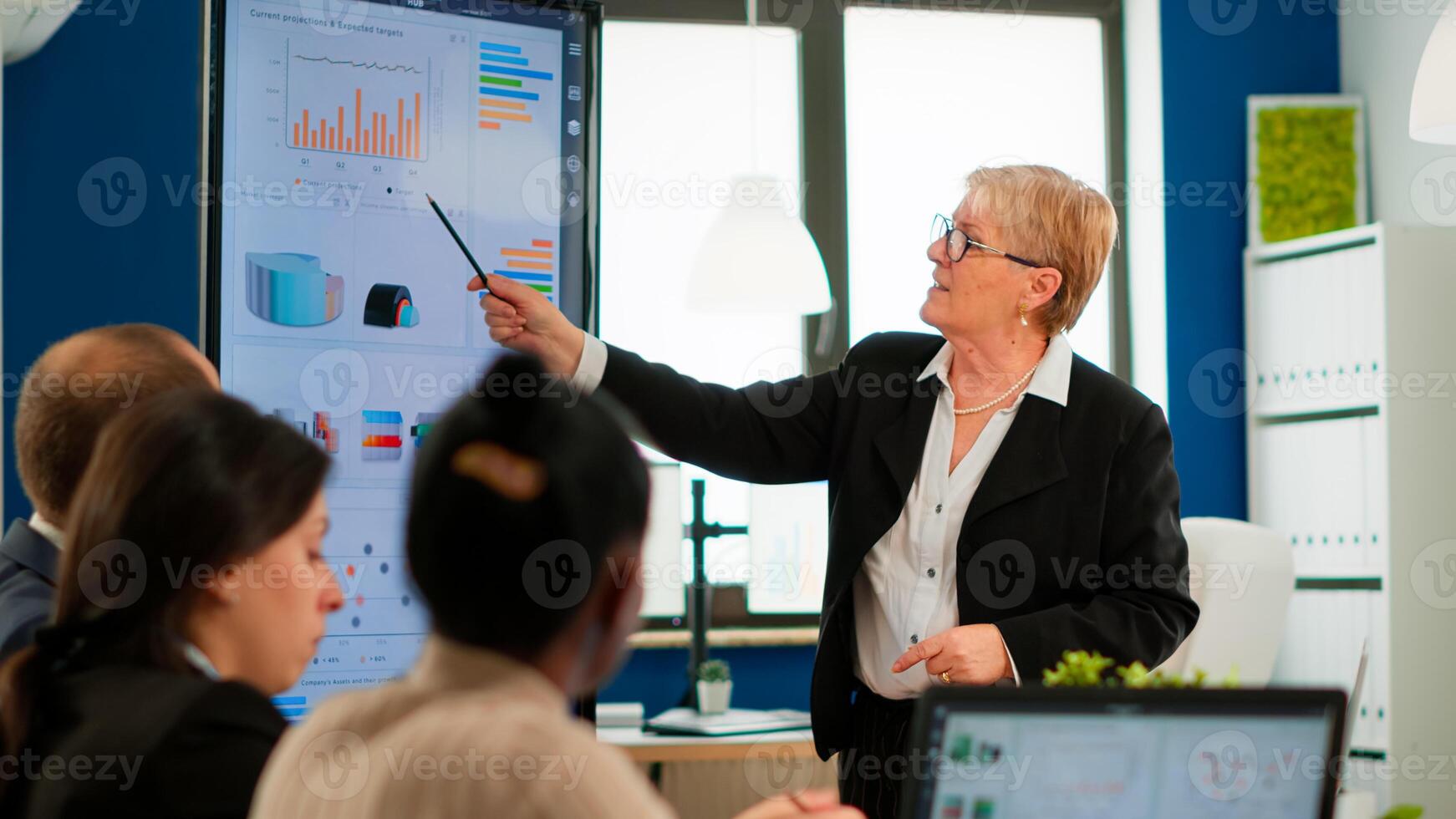 Serious senior manager executive and diverse team people analyzing digital project presentation briefing, sharing ideas in teamwork, discussing financial plan in office corporate meeting room photo