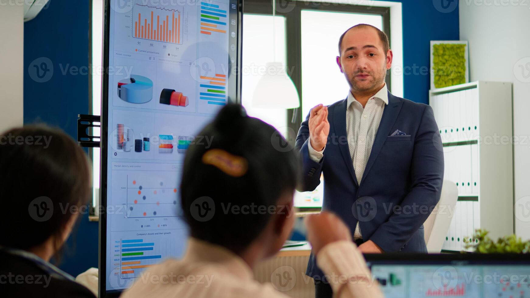 Professional man entrepreneur planning new project with his coworkers, explaning company strategy during brainstorming. Diverse team working in professional startup financial office during conference photo