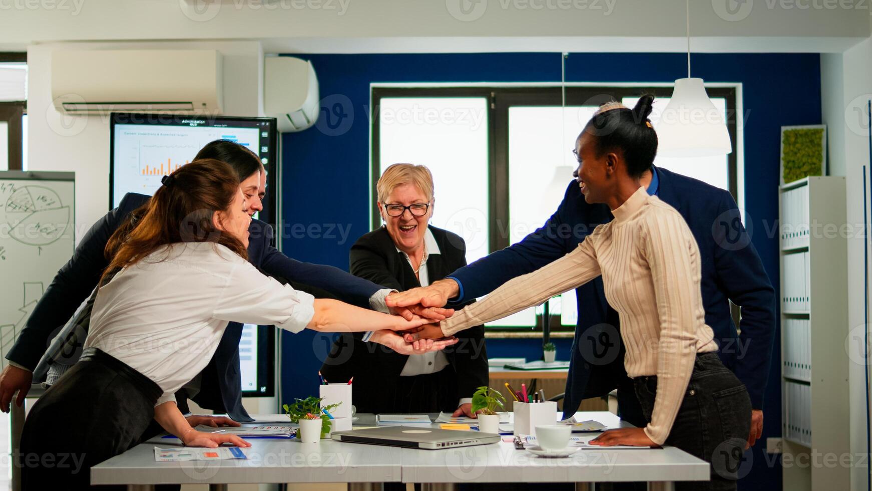 Happy diverse colleagues with new business opportunity enjoing victory. Overjoyed multiethnic company team throwing up hands celebrating successful project, receving good news. photo
