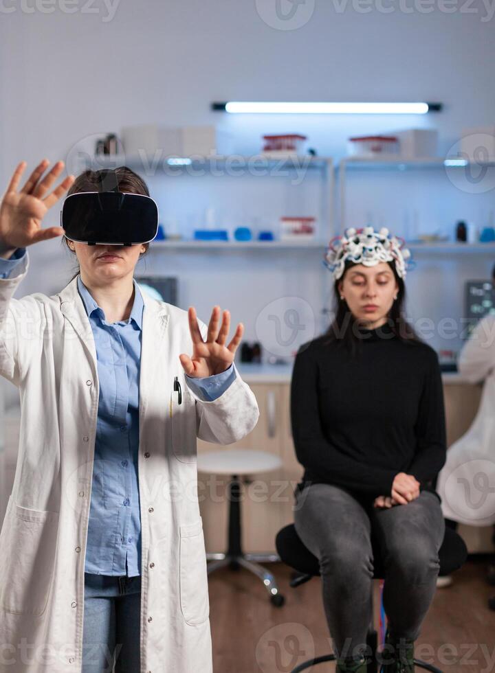 Laboratory doctor experiencing virtual reality using vr goggles in medical neurological research lab. Physician therapist using medical innovation equipment device glasses, analysing brain scan. photo