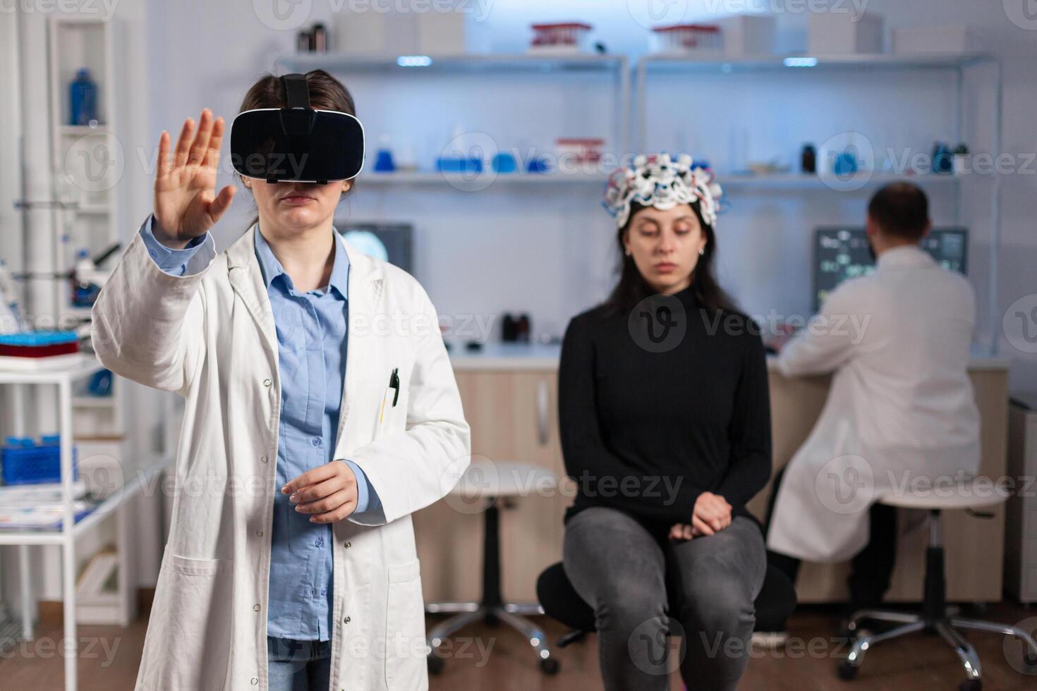 Professional researcher wearing virtual reality glasses using medical inovation in lab analysing brain scan of patient. Team of neurological doctors working with equipment high tech simulator device. photo