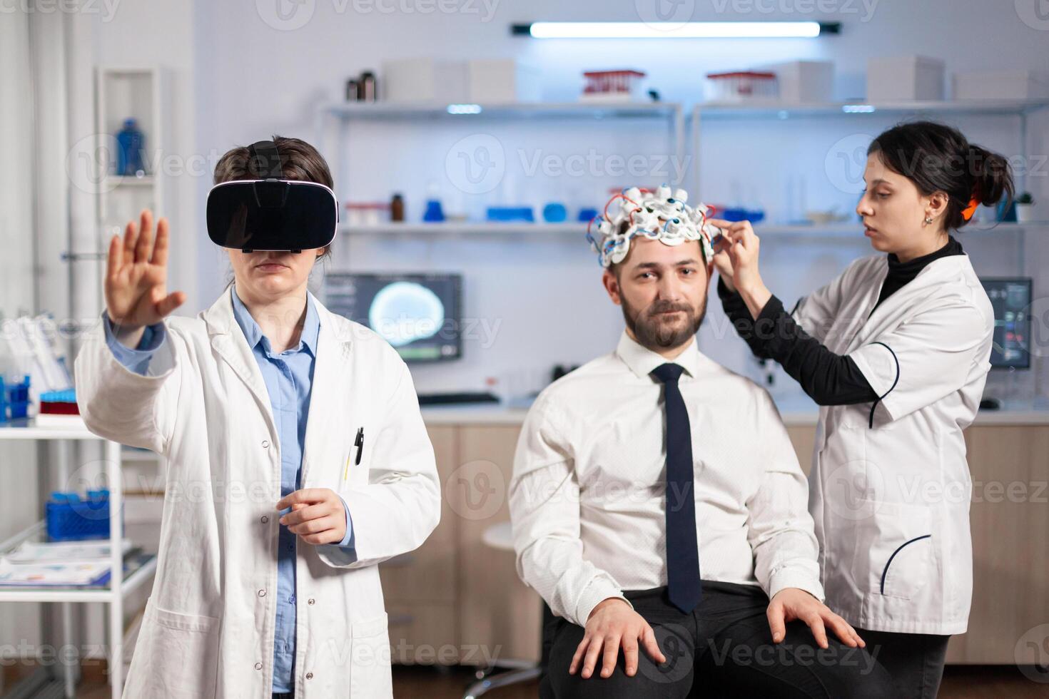 Neuroscientist wearing virtual reality headset looking at patient brain activity, wearing high tech sensors for scanning. Doctor searching diagnosis, experiment , eeg , medicine lab. photo