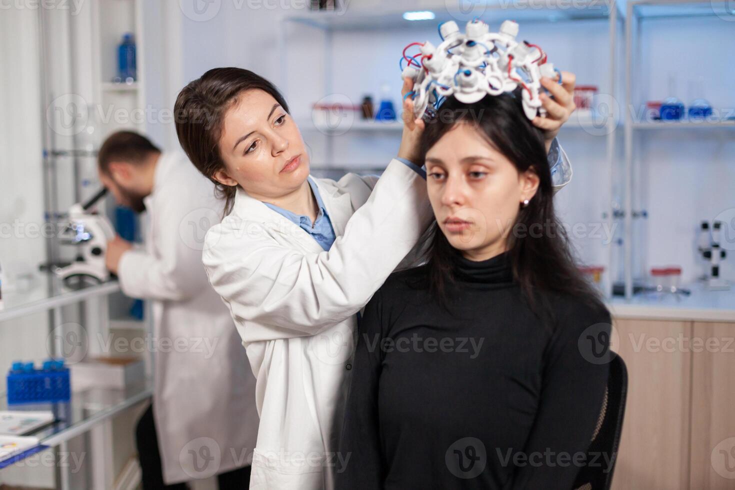 Neurologist in moden clinic preparing patient headset with sensors for brain scan with high tech technology device, tomography. Searching diagnosis for ill nervous system. photo