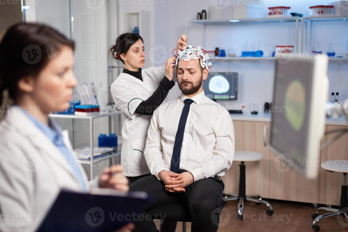 Man patient visiting professional medical researcher in neurology medicine testing brain functions with eeg headset. Doctor monitoring nervous system, descovering diagnosis of disease. photo
