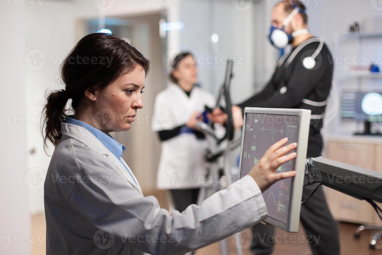 Professional male runner testing his muscle endurance in science sport lab facility, running with electrodes attached to his body monitoring health conditions, heart rate, psychological resistance. photo
