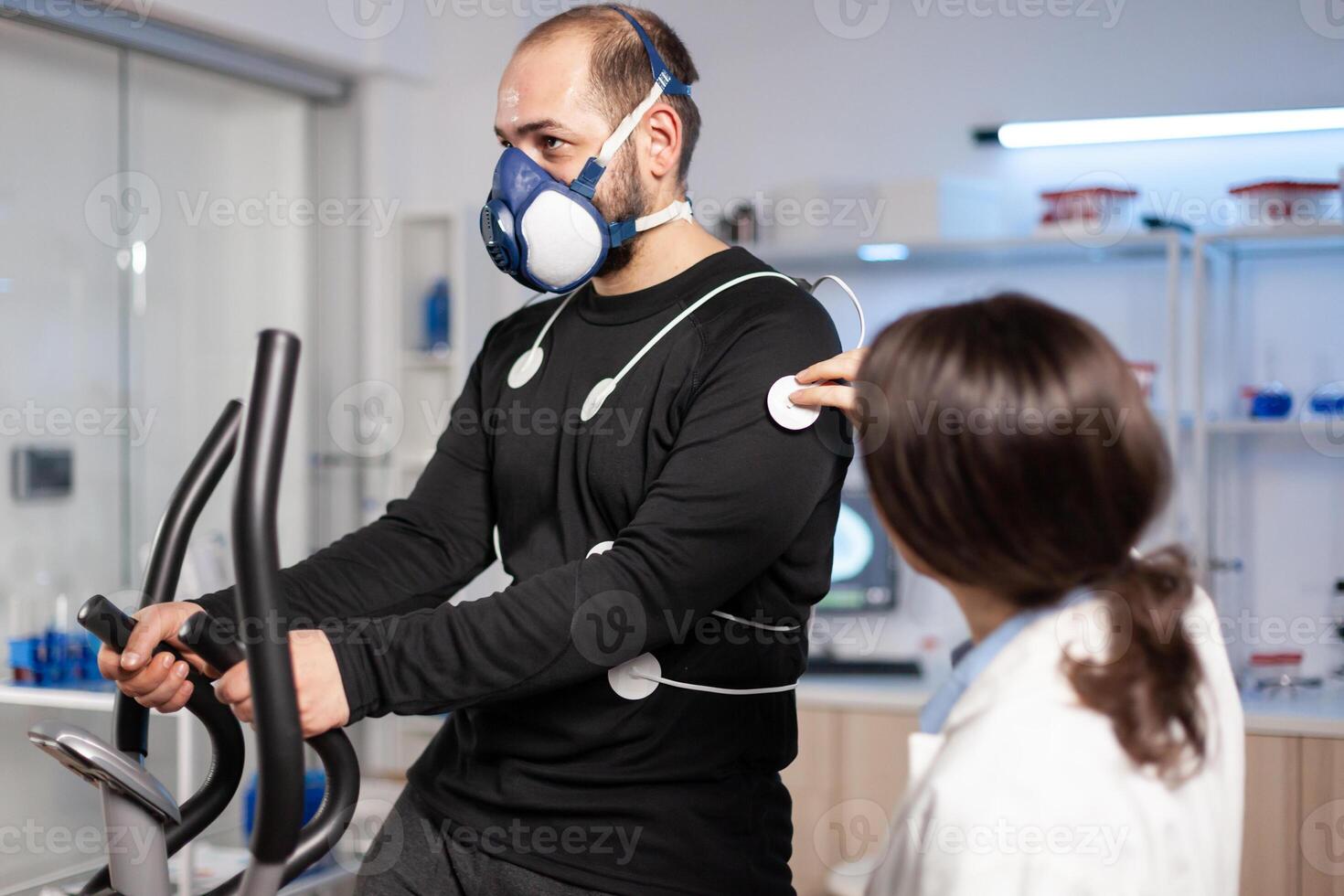 Sport researcher in test examination of athlete performance, monitoring, electrodes on body, running heart rate cardio. Body endurance analyzing sensors equipment machine, sportman. photo