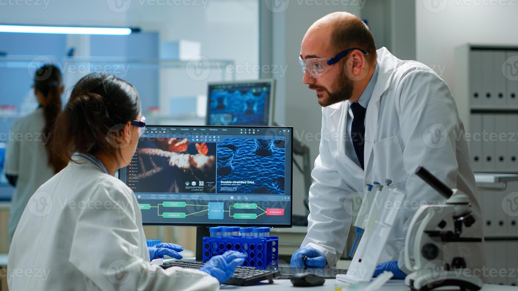 Team of scientists worried about virus evolution discussing in equipped laboratory pointing at computer. Stuff examining vaccine development using high tech researching treatment against covid19 virus photo