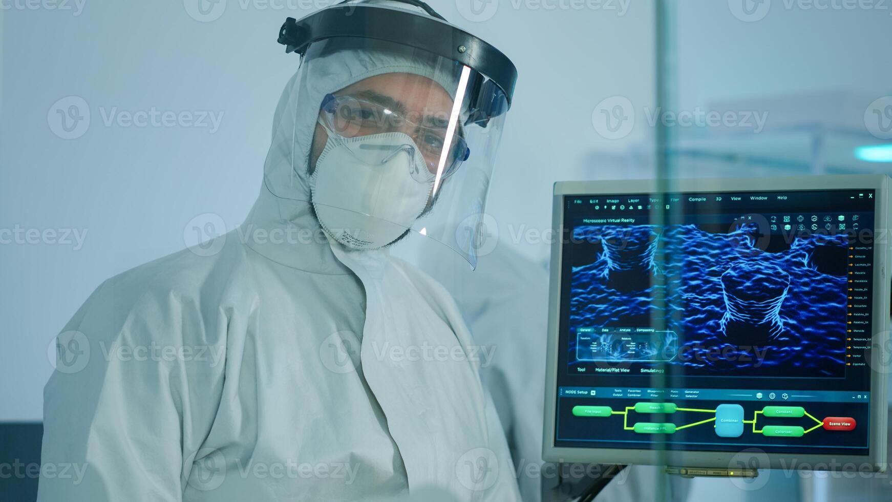 Microbiologist in ppe suit standing in laboratory looking at camera behind the glass wall in equipped lab. Doctor examining virus evolution using high tech and chemistry tools for vaccine development photo