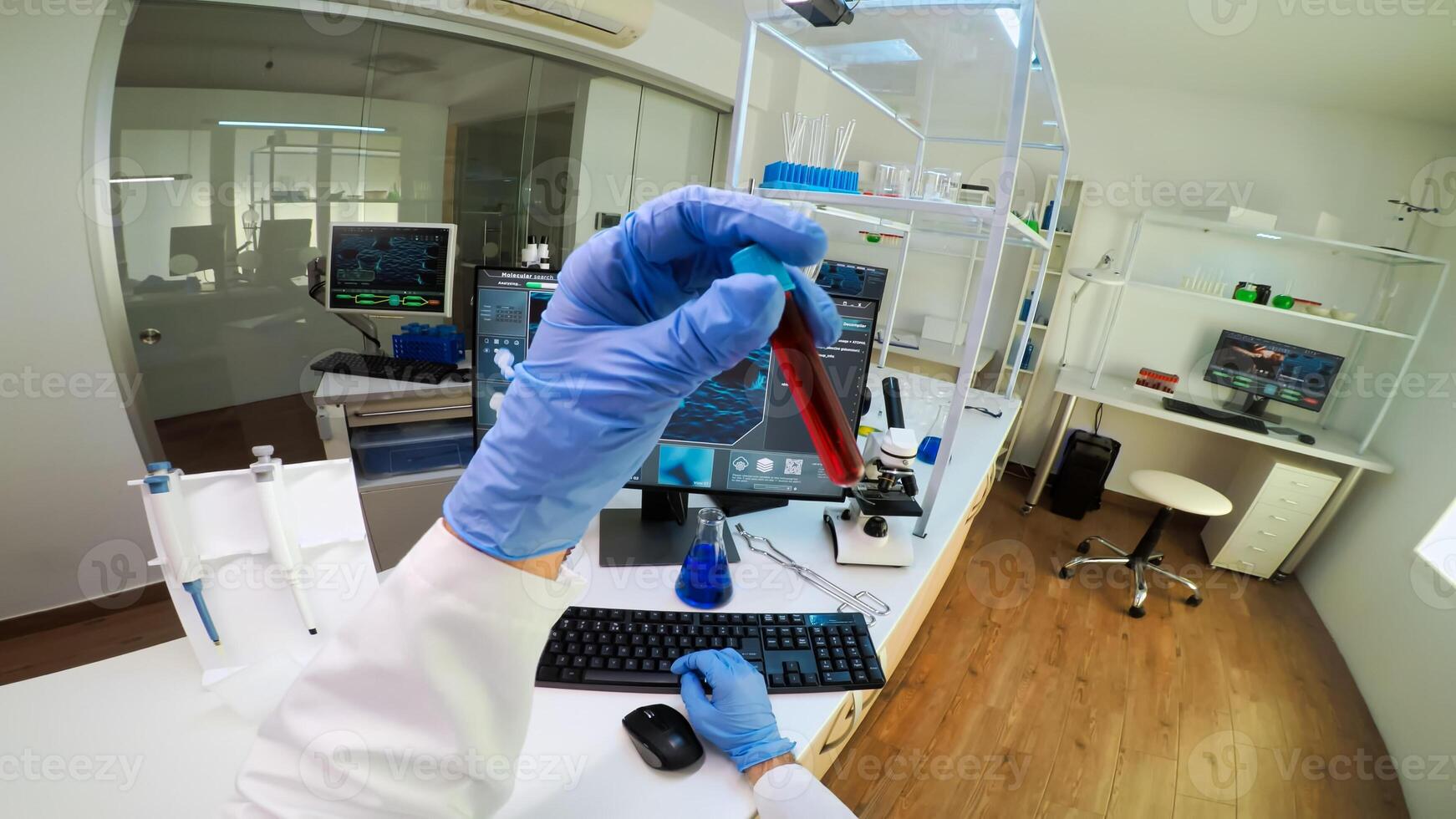 POV of scientist analysing blood sample from test tube typing on computer. Viorolog researcher in professional lab working to discover medical treatment, team of doctors analysing vaccine evolution photo