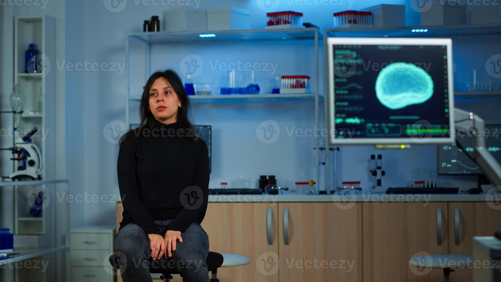 Wired patient waiting scientist doctor in neurological research laboratory visiting scientists examining tomography scan. Woman sitting in lab equipped for development of experiments photo