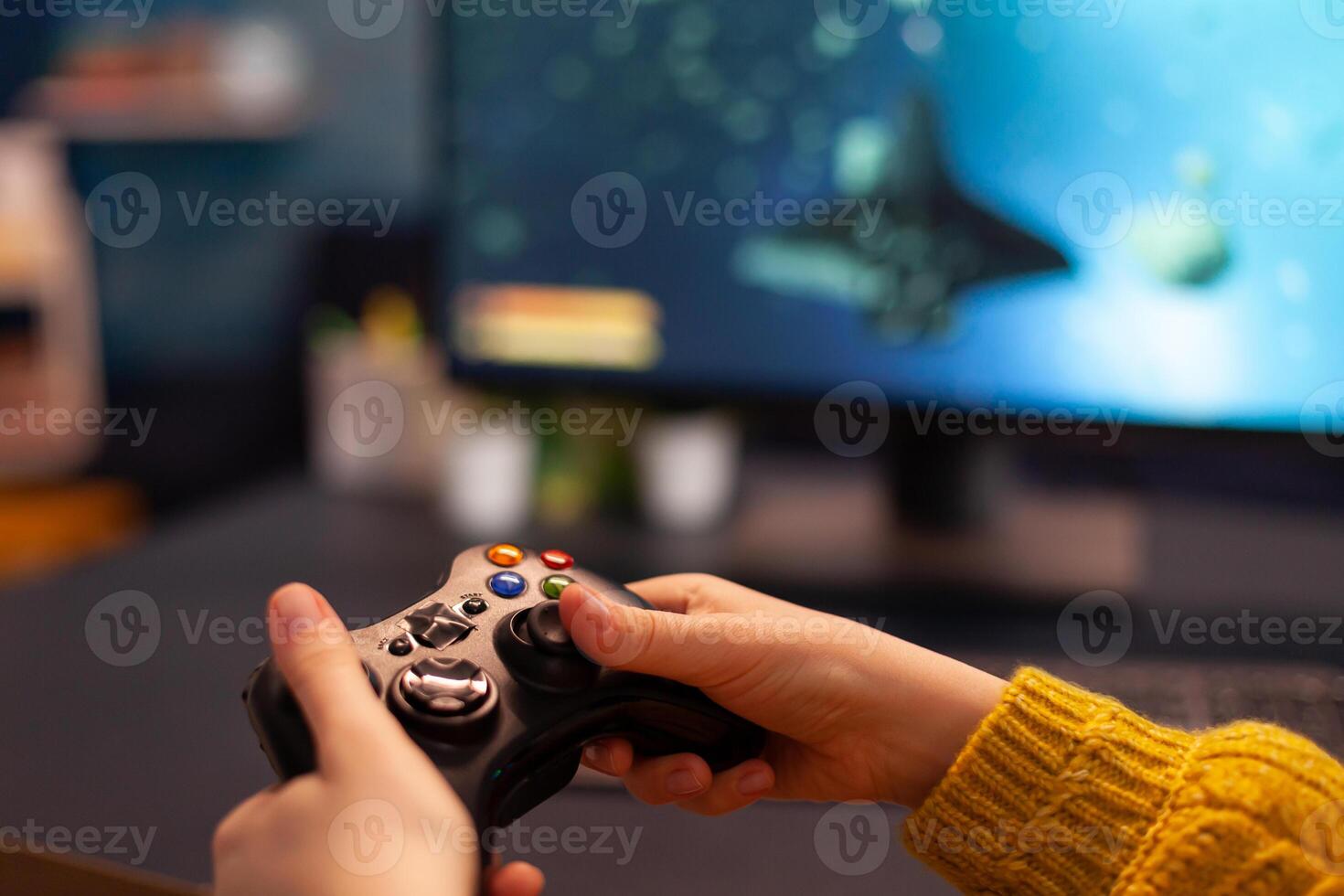 Close-up of professional cyber gamer holding joystick playing space shooter game. Pro player use equipment during gaming tournament late at night in home studio using wireless controller photo