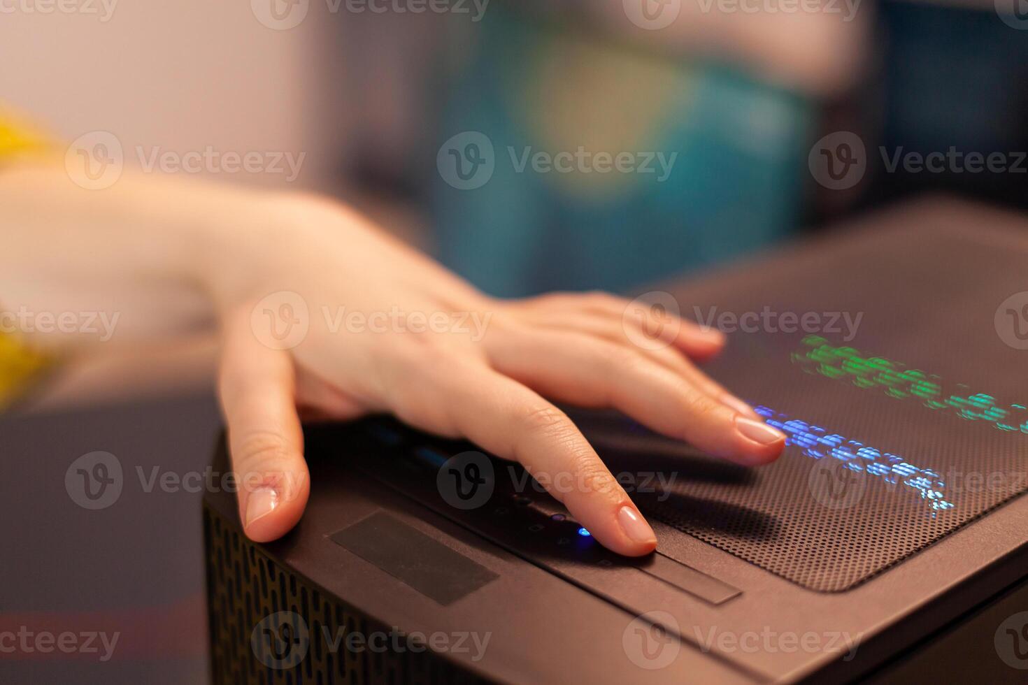 Woman gamer power on computer unit preparing for gaming tournament. Cyber performing on powerful personal computer in stylish room starting to play online shooter game. photo