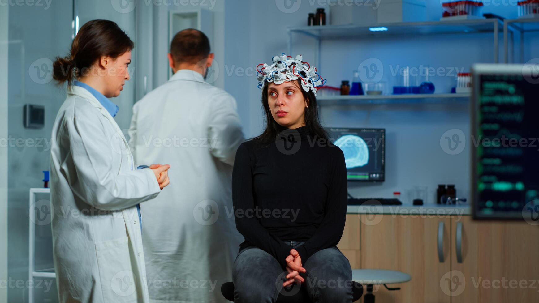 Expert medic in neuroscience developing brain experiment holding laptop explaning to woman side effects of nervous system treamtment. Team of scientists working in neurological research laboratory photo