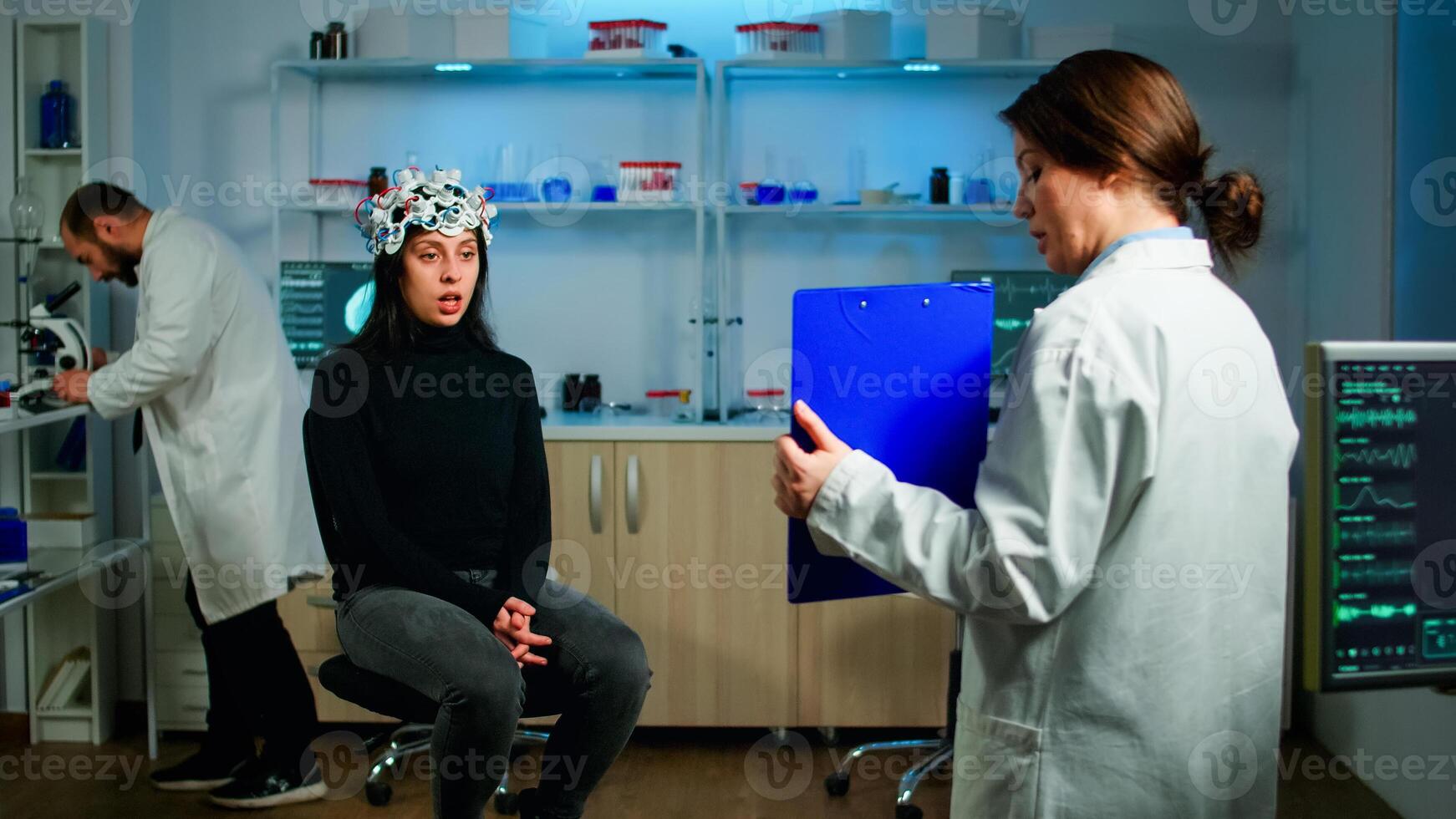 Professional doctor in neurological medicine testing eyesight of patient with eeg headset. Medical reasearcher examining evolution of treatment against diseases of nervous system in equipped lab photo