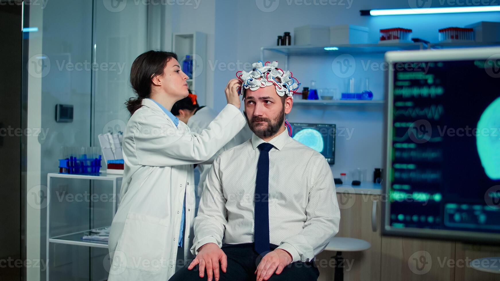 Man patient visiting professional medical researcher in neurology medicine testing brain functions with eeg headset. Doctor monitoring nervous system, descovering diagnosis of disease. photo